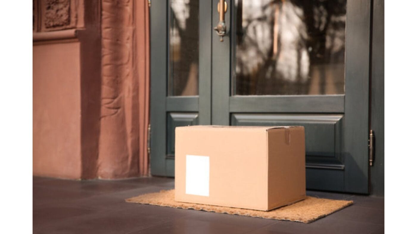 Sealed, unbranded shipping box placed at a home doorstep