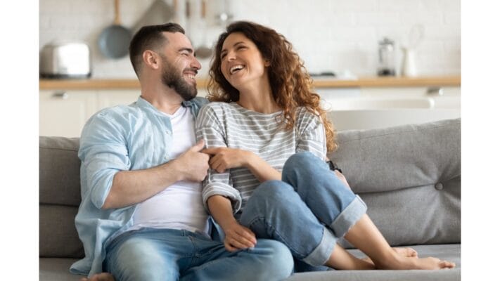 A couple sitting together, smiling and communicating openly in a calm environment